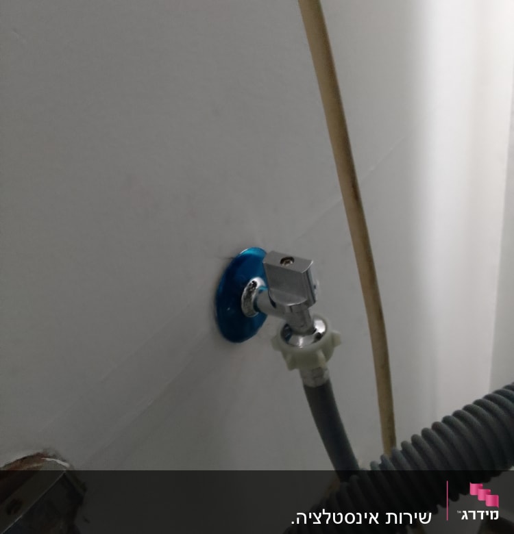 ברז מים עם צינור גמיש מחובר לקיר